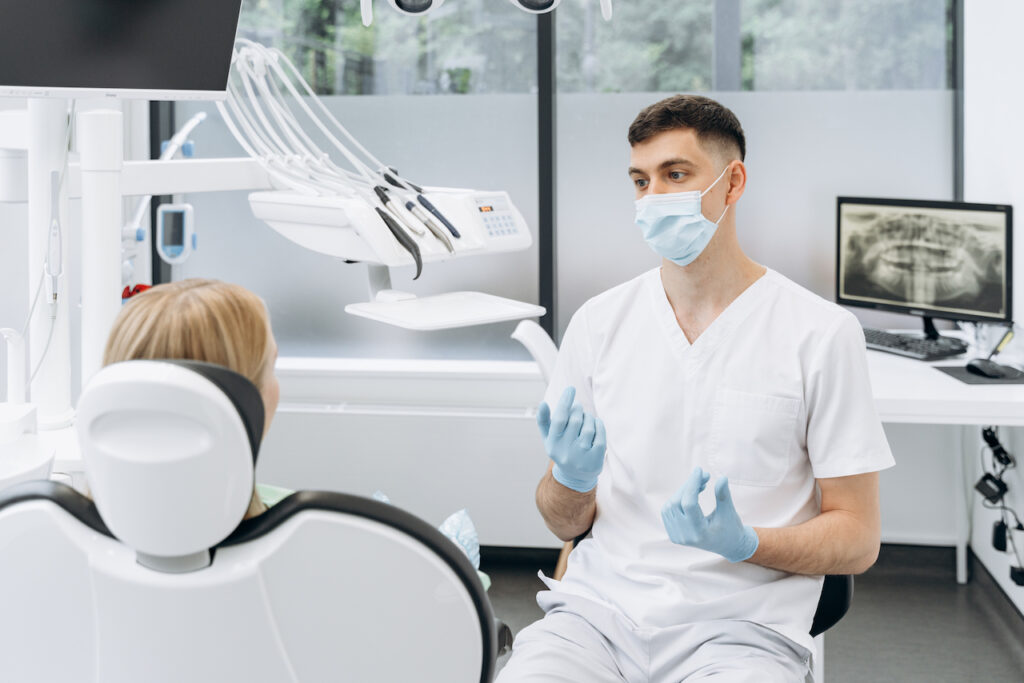 dentist explaining dental bridge vs implant to patient