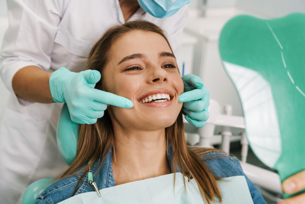 woman in dental chair after having invisalign or braces for straightening her teeth