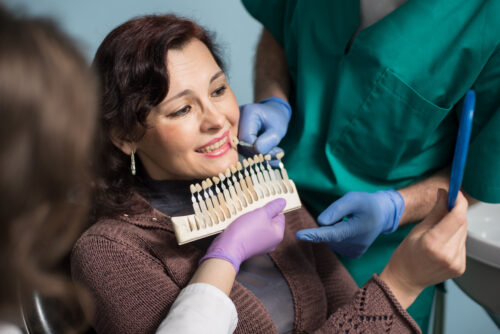 Dentist and assistant explaining benefits of dental implants to patient