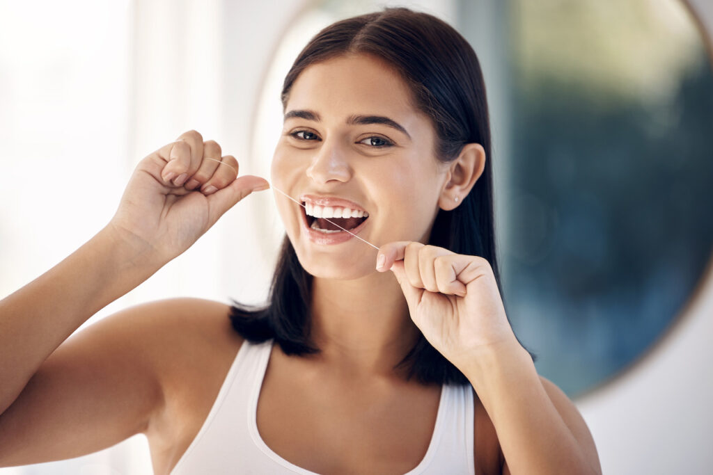 woman flossing to prevent bad breath